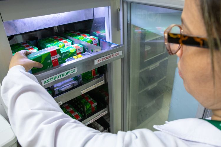 Profissional de saúde retirando produto do estoque de antivenenos do HVB