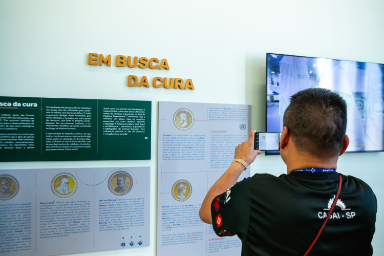 O pedagogo tira fotos das exposições do edifício Vital Brazil