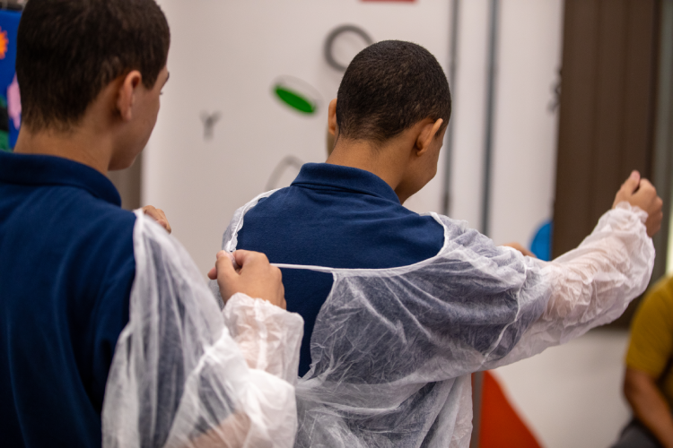 Meninos vestiram jalecos para participar de atividade que simula o desenvolvimento de uma vacina