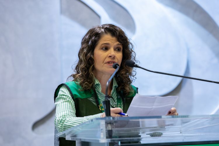 Pesquisadora falando em púlpito