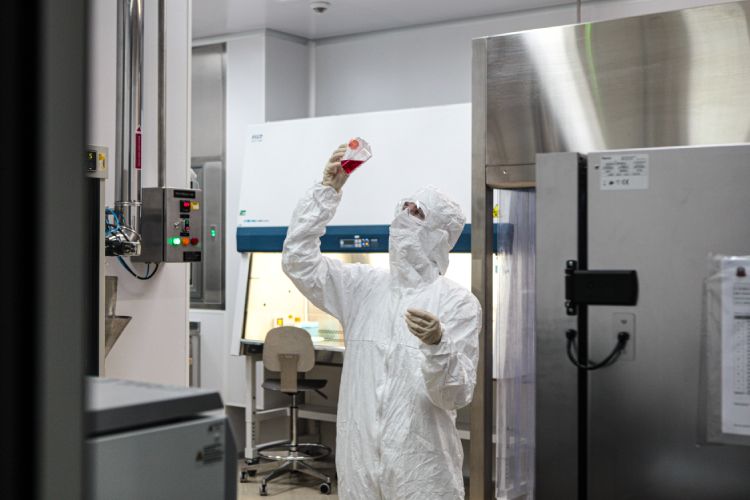 Colaborador paramentando avaliando substância em ambiente de fábrica