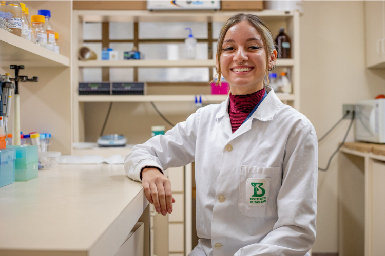 Jovem cientista Sthefany Alves usando jaleco em laboratório